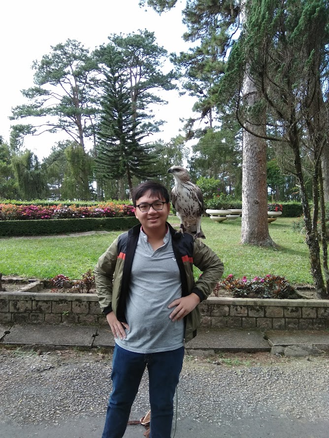 Vinh Bui sitting in the park with a book